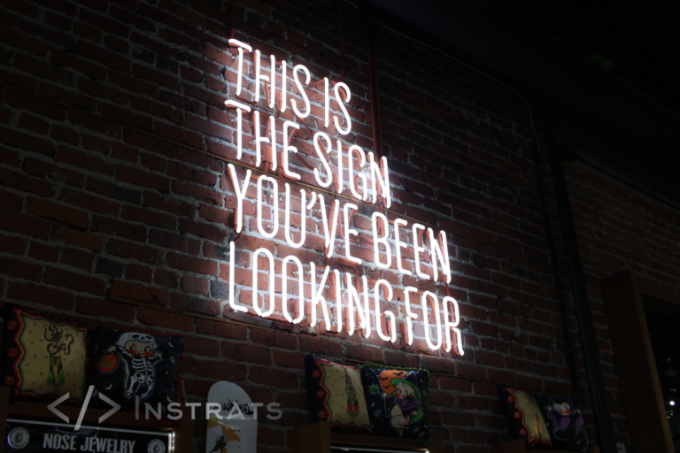 A glowing neon sign stating, "This is the sign you've been waiting for.